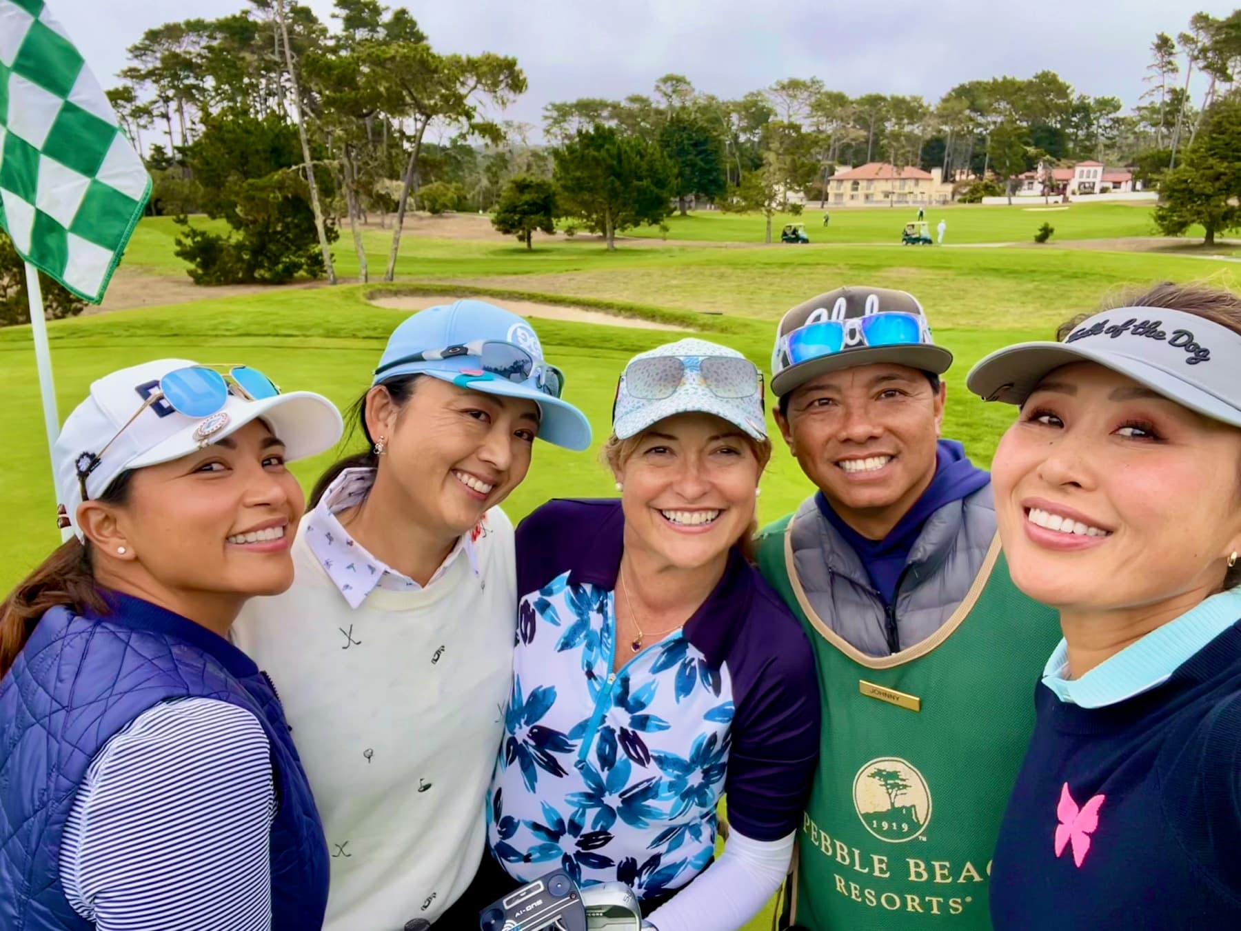 Johnny in a group selfie with four women golfers by the flag