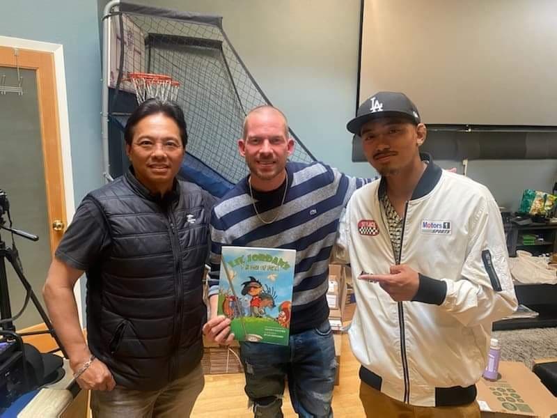 Johnny and two others with the book in a studio