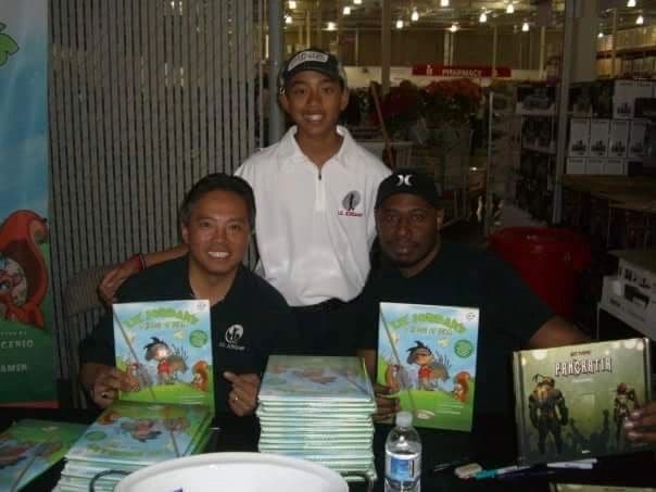 Signing copies of the book at a table