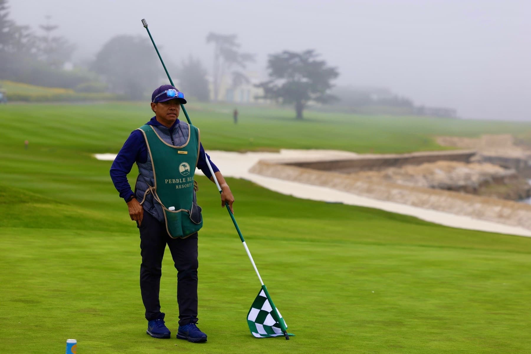Johnny tending the flag beside the bunker and seawall in the fog
