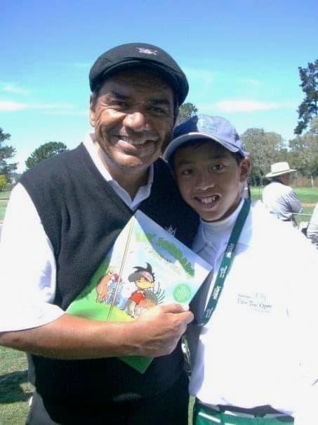 Lil' Jordan with a supporter and the book at a golf event