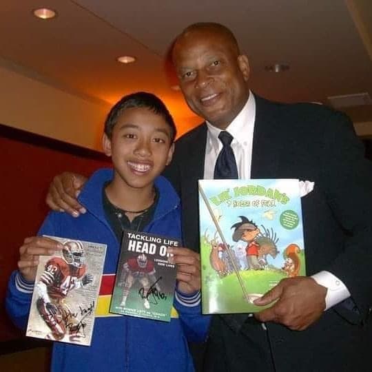 Lil' Jordan holding the book with a supporter