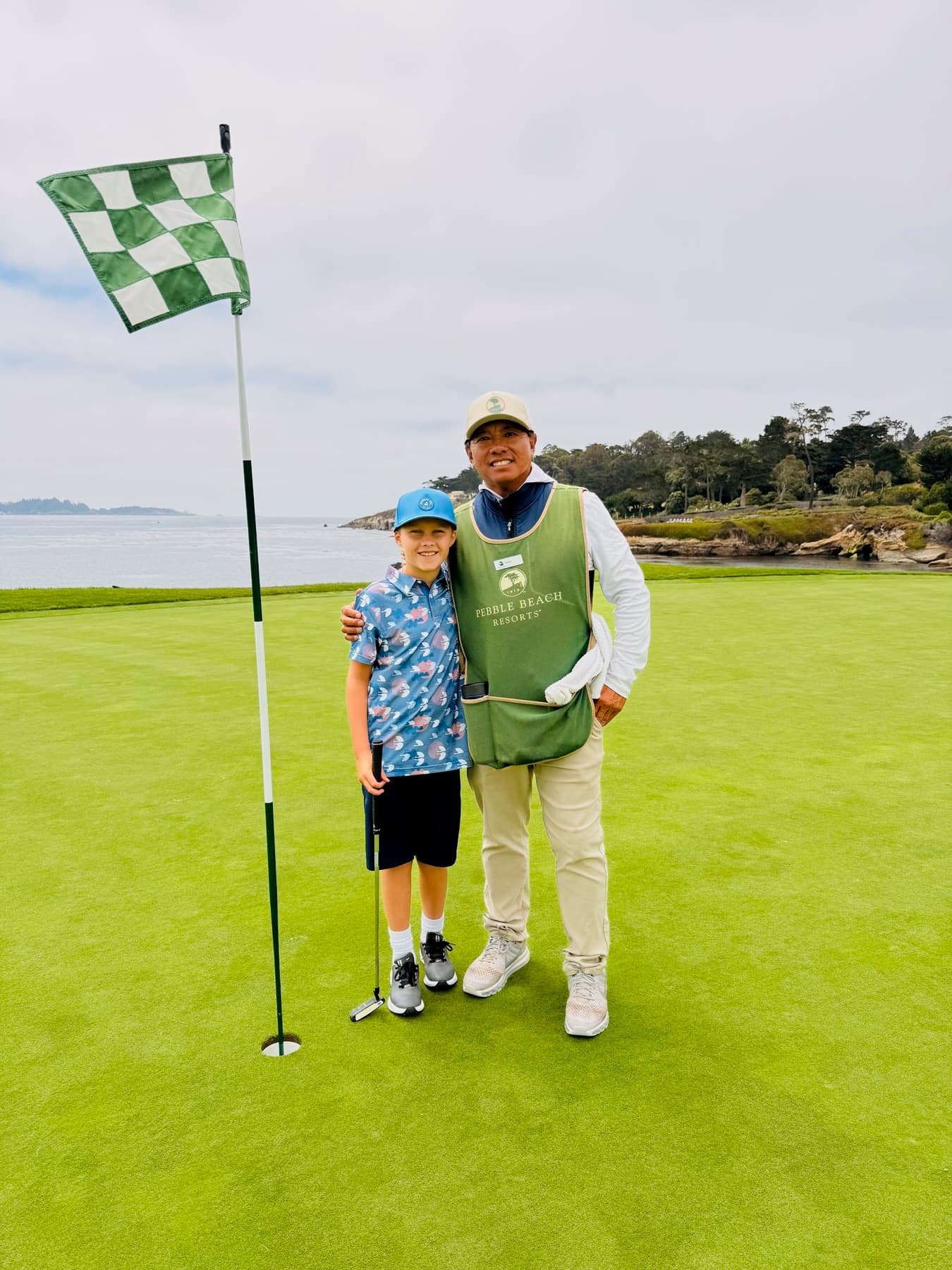 Johnny with a junior golfer beside the checkered flag