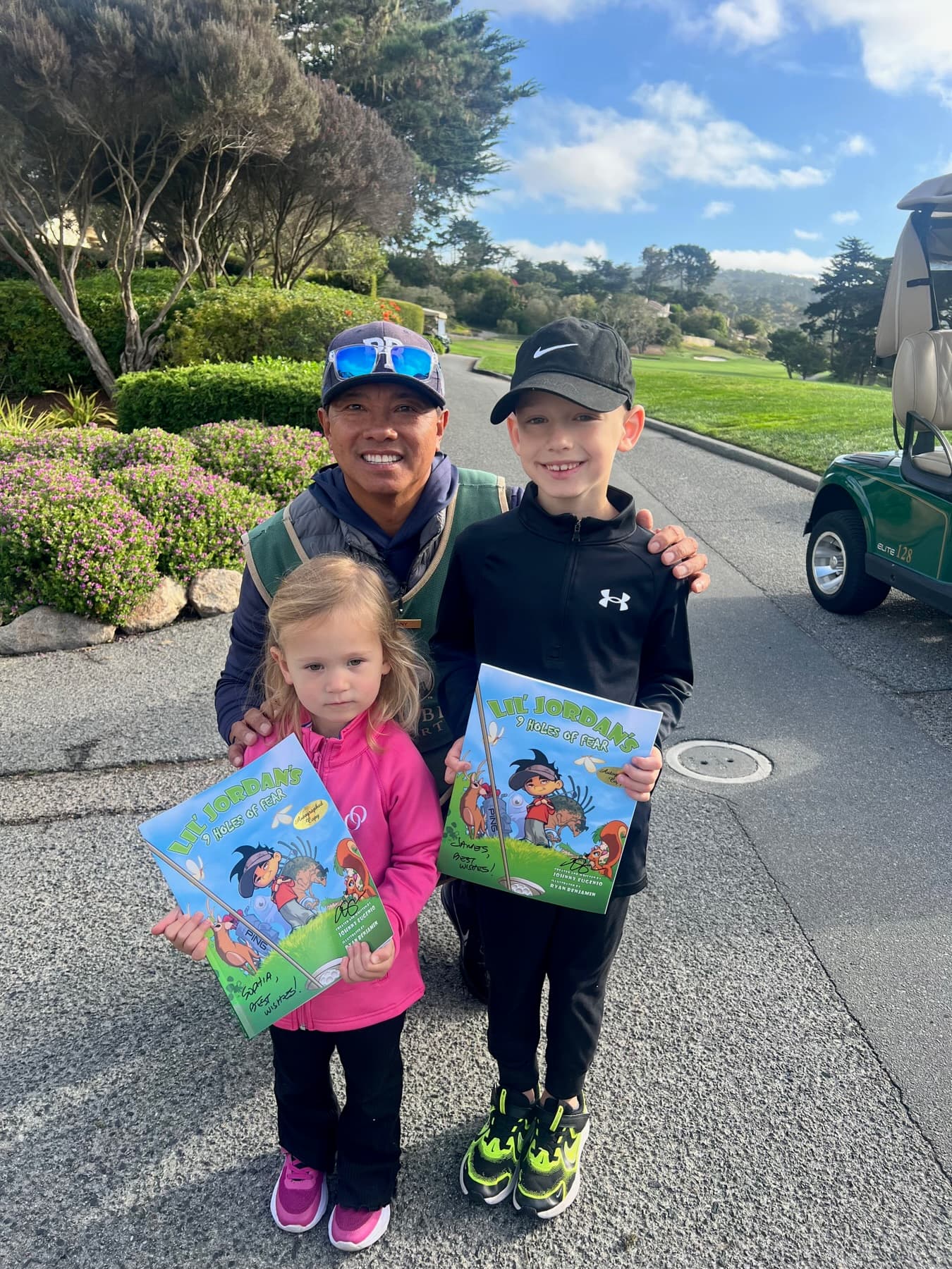Johnny with two young readers holding the book