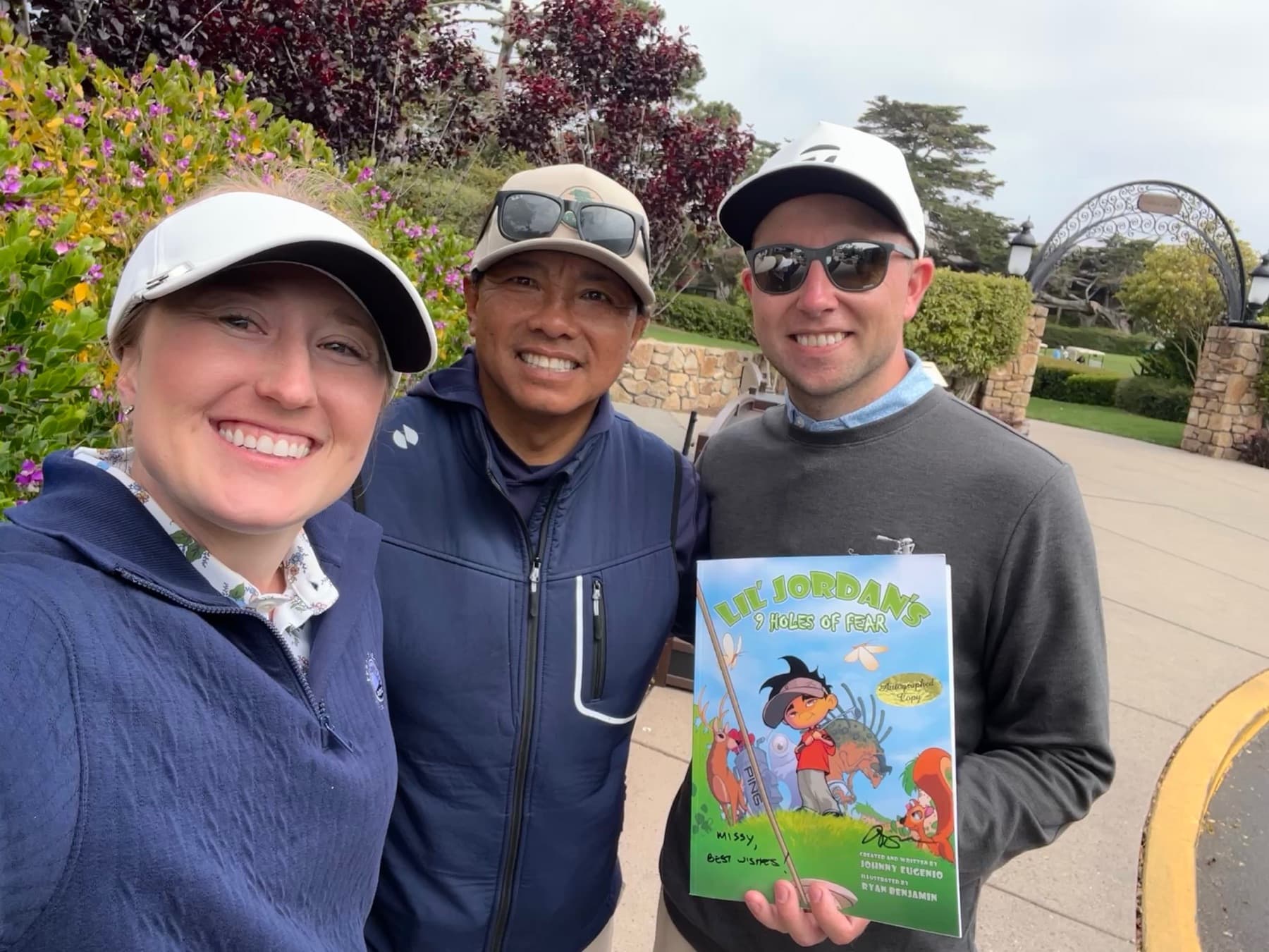 Johnny and two golfers with a copy of the book